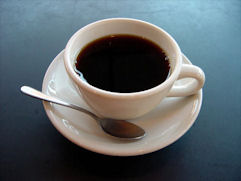 black-coffee-cup-saucer-white-silver-spoon-grey-blue-surface-photo.jpg